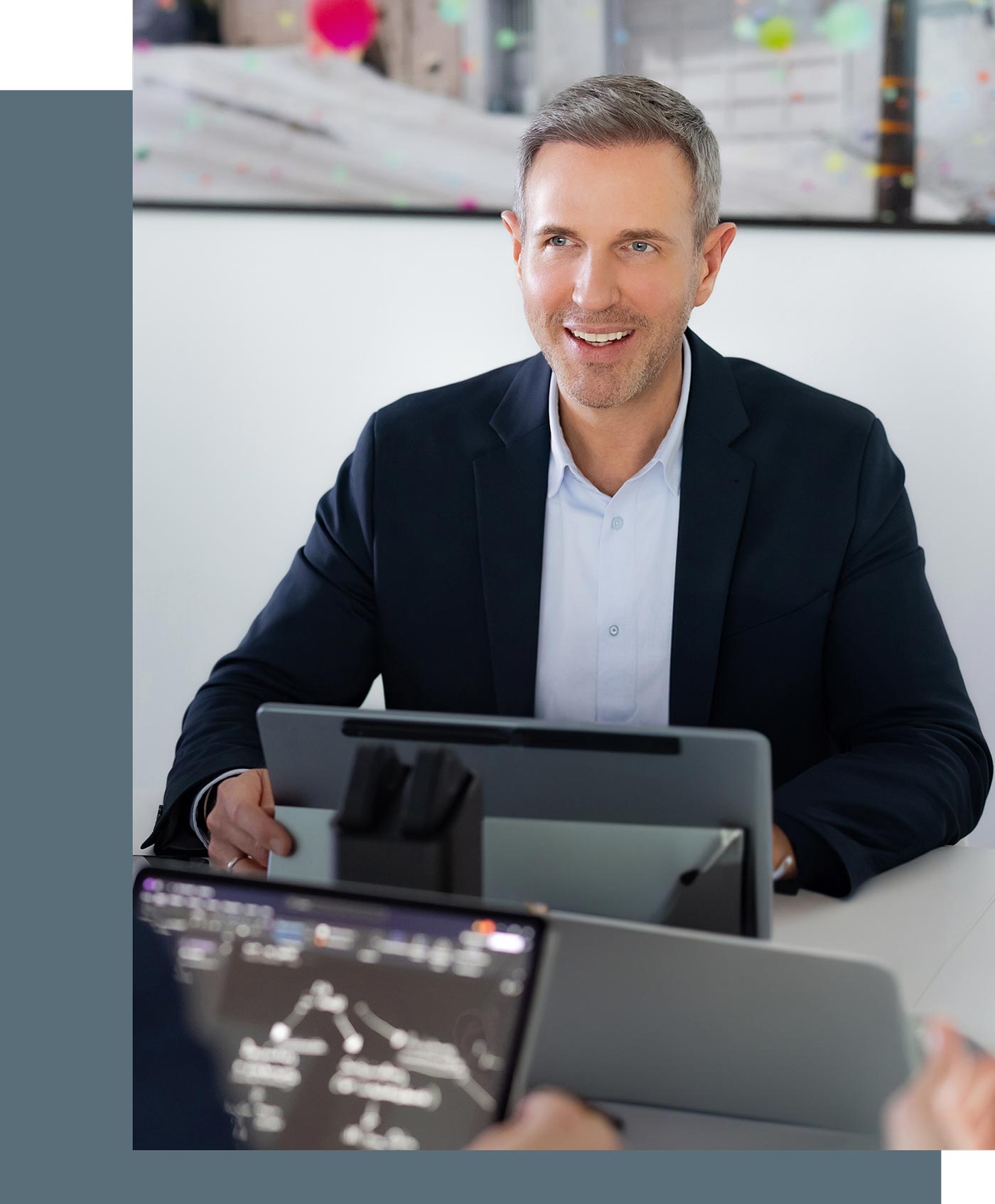 Steuerberater Benjamin Vogel während einer Besprechung, vor ihm steht ein Laptop