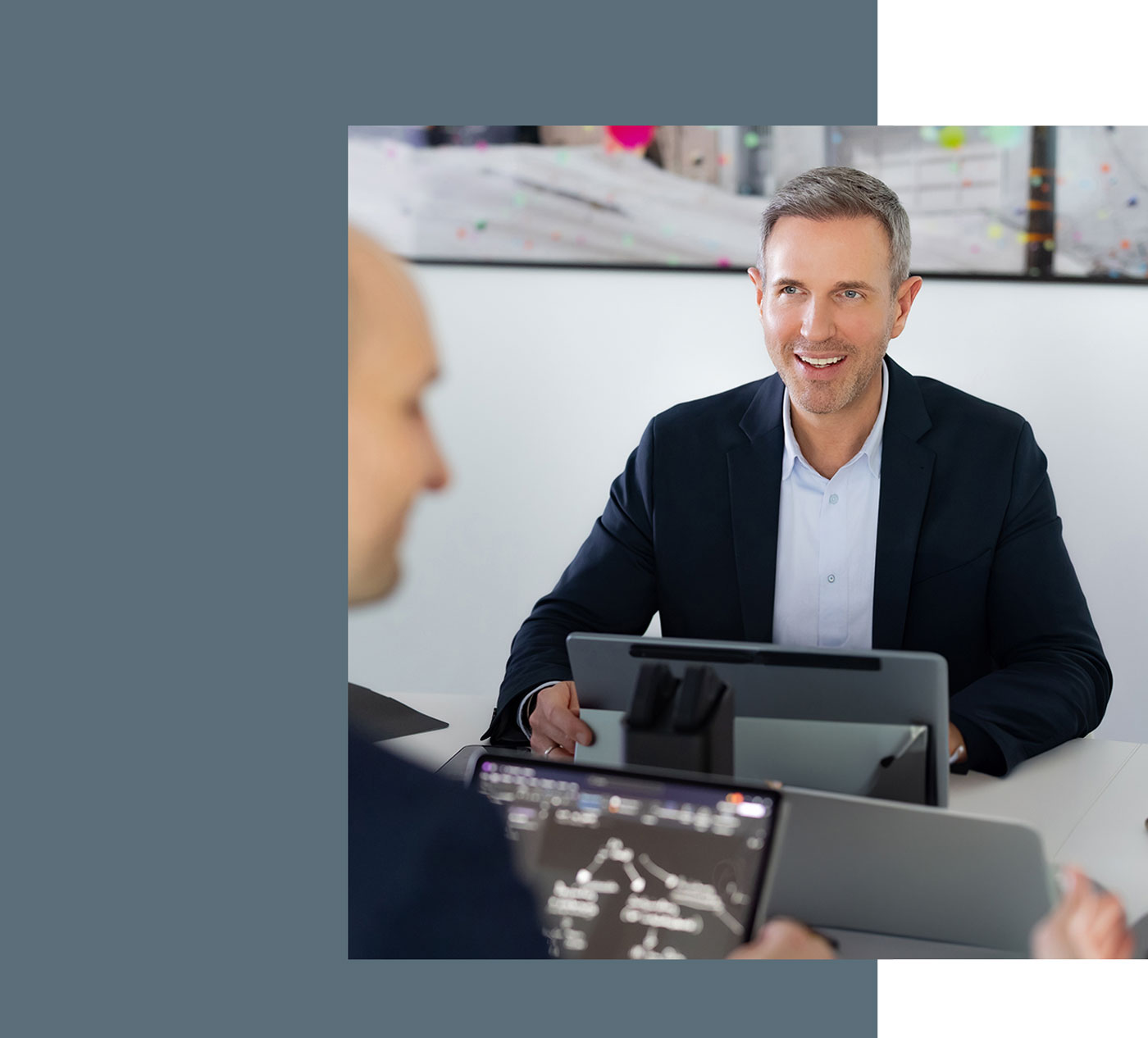 Steuerberater Benjamin Vogel während einer Besprechung, vor ihm steht ein Laptop