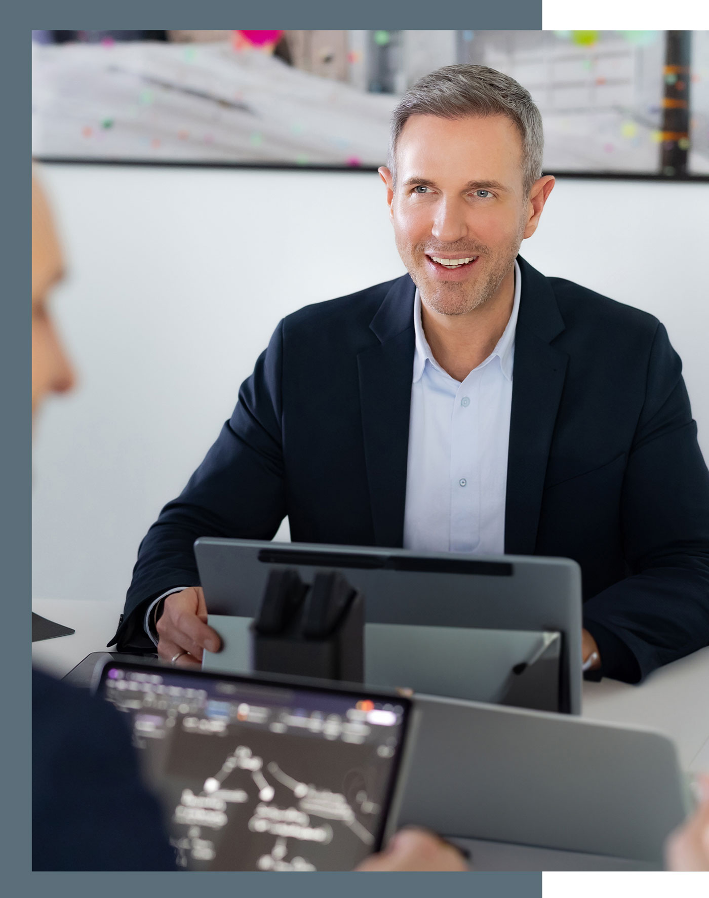 Steuerberater Benjamin Vogel während einer Besprechung, vor ihm steht ein Laptop