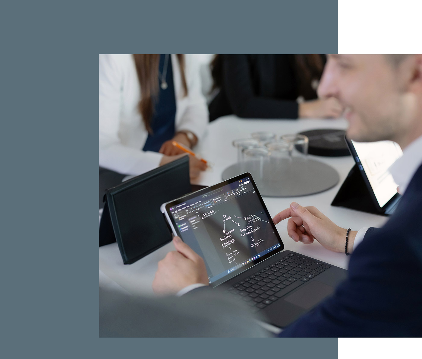 Detailansicht eines Tablets während einer Besprechung, auf dem Tablet sind schematisch Strukturen und Abläufe skizziert