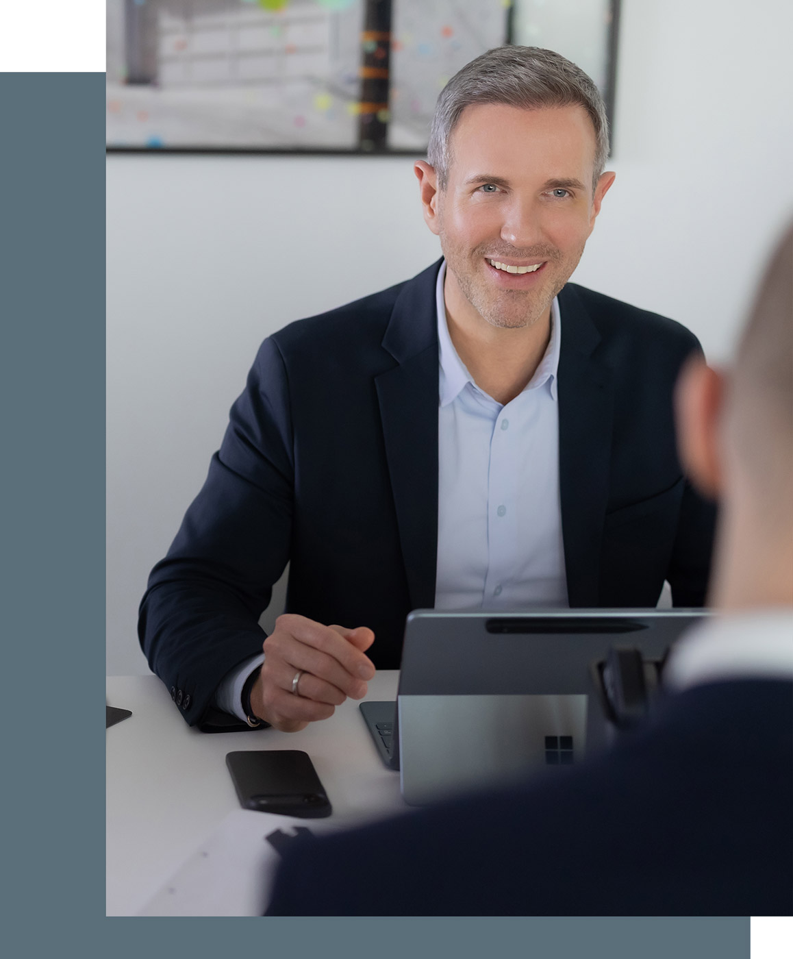 Benjamin Vogel, Steuerberater und Partner bei RV, sitzt am Besprechungstisch und hat einen Laptop vor sich stehen