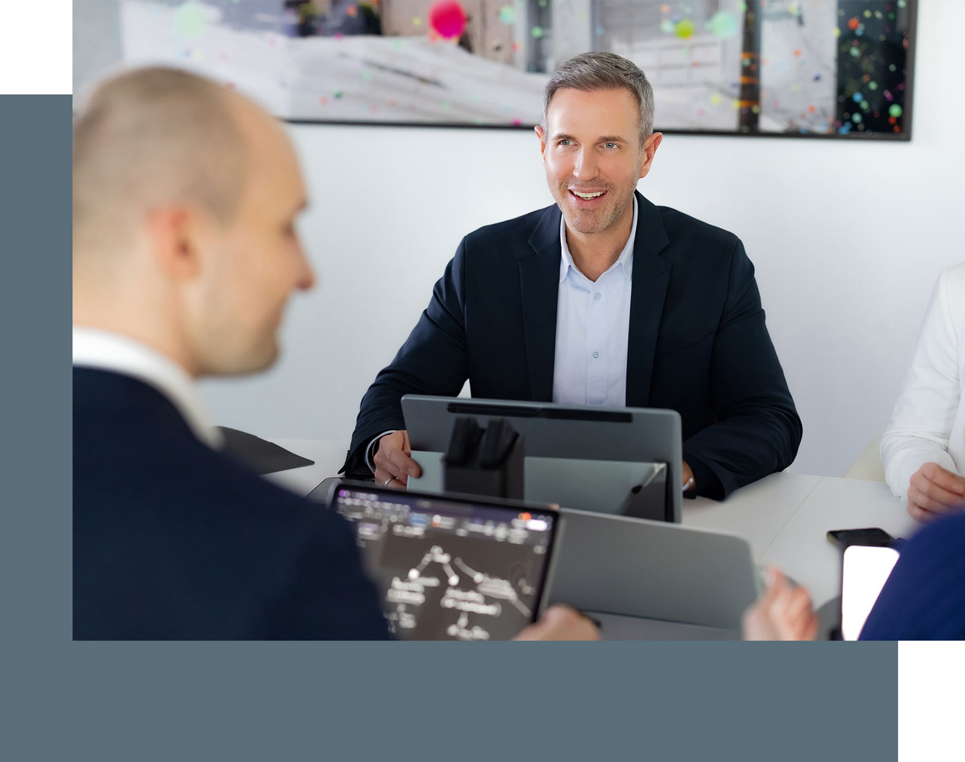Steuerberater Benjamin Vogel während einer Besprechung, vor ihm steht ein Laptop