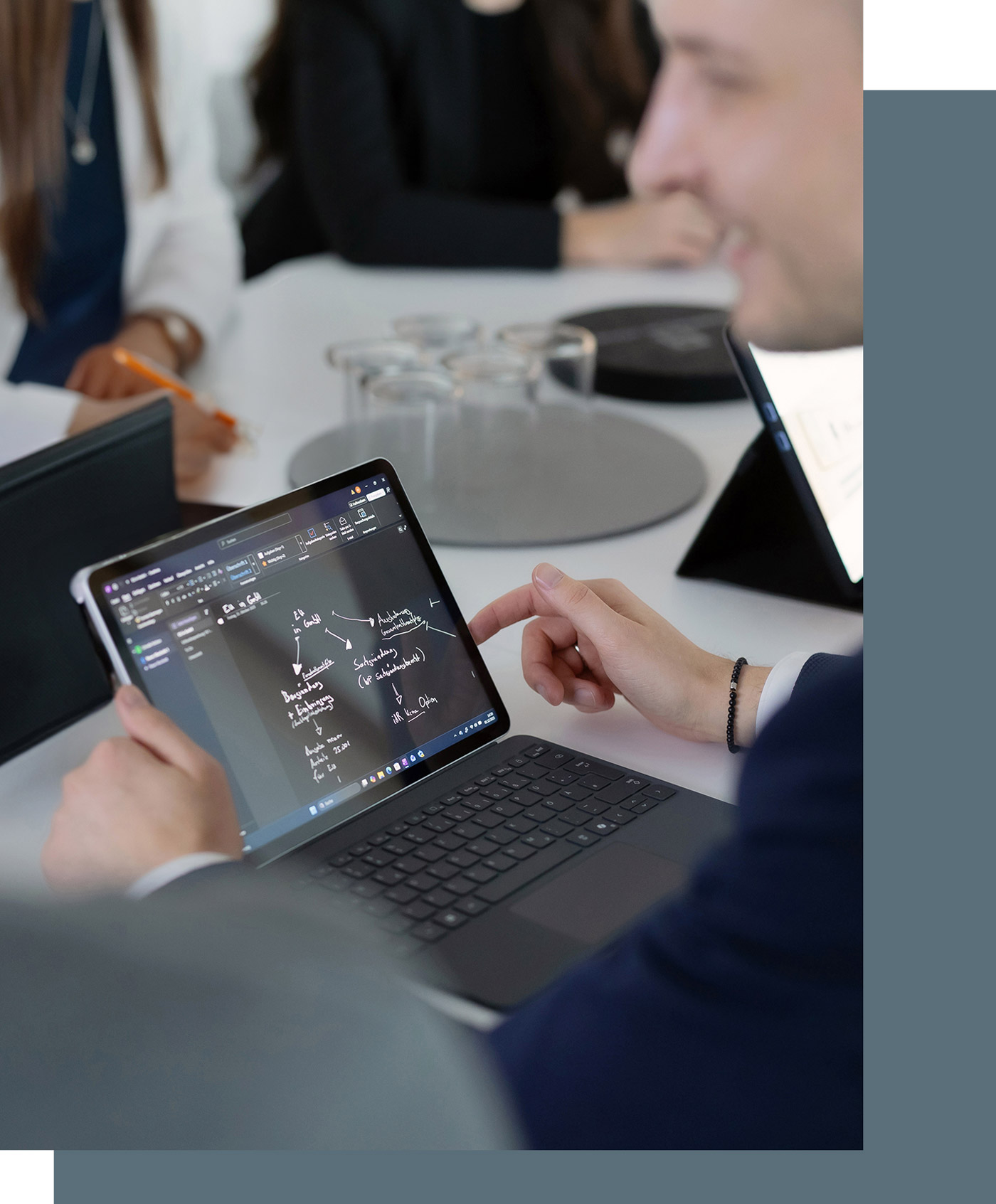 Detailansicht eines Tablets während einer Besprechung, auf dem Tablet sind schematisch Strukturen und Abläufe skizziert
