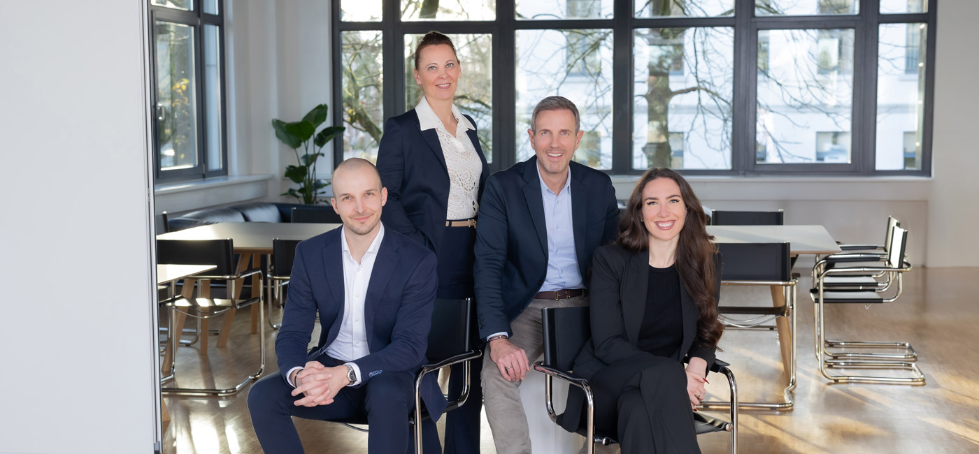 Das RV-Berater-Team Alexander Schmackey, Ina Bergen, Benjamin Vogel und Julia Düntzer - alle Steuerberater in Solingen - sitzt und steht im Besprechungsraum